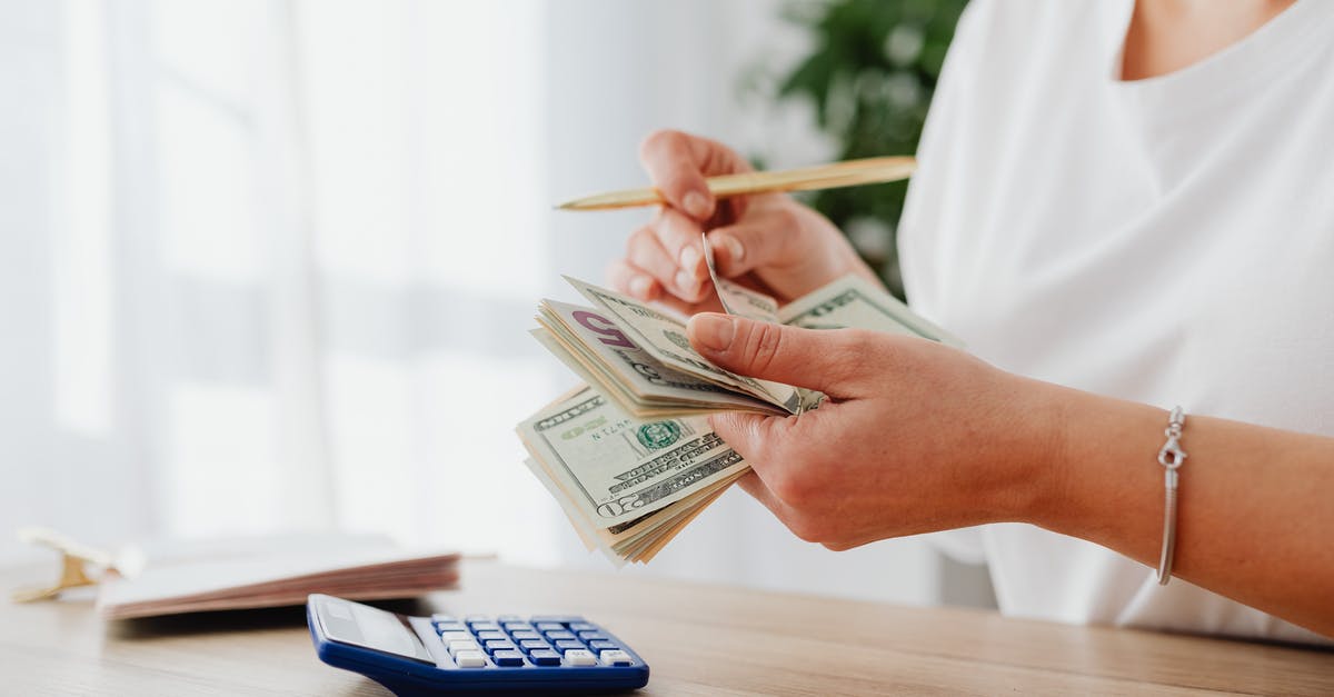 JFK to New Jersey on a student's budget - Woman Counting Money with Calculator JFK to New Jersey on a student's budget - Woman Counting Money with Calculator