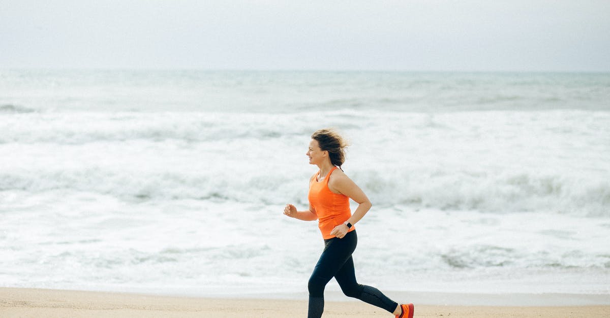Jogging in Tokyo and Osaka - Woman in White Tank Top and Black Leggings Running on Beach Jogging in Tokyo and Osaka - Woman in White Tank Top and Black Leggings Running on Beach