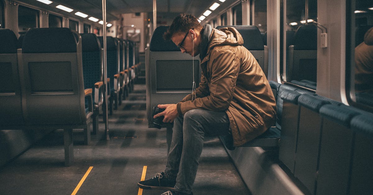 Journey planner for finding intercity train connections in China? - Young stylish guy checking photos on camera while riding on train Journey planner for finding intercity train connections in China? - Young stylish guy checking photos on camera while riding on train