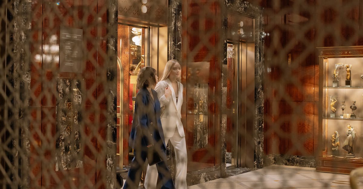 Krisflyer Gold Lounge extra guest access - Woman in Blue Suit Standing Beside Woman in White Coat