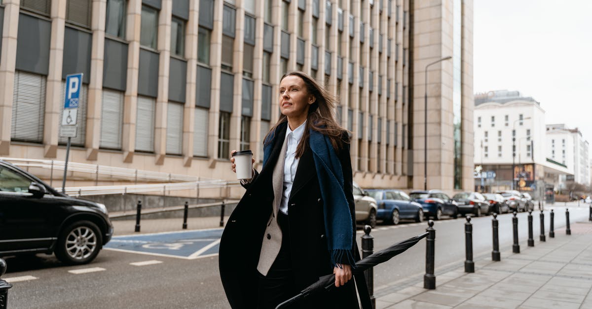L/100 km or km/L? which one is used? I am planning travel in Mexico & Colombia by car [closed] - Woman in Black Blazer and Black Dress Standing on Sidewalk