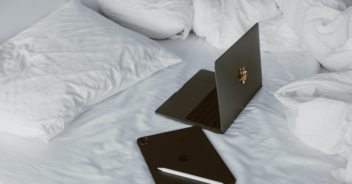 Laptop and tablet restrictions within US air travel - Black Macbook on White Bed Laptop and tablet restrictions within US air travel - Black Macbook on White Bed