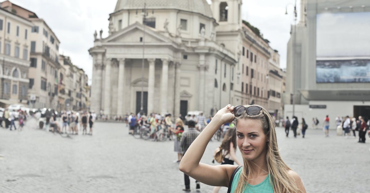Layover at DEL T3 Holiday Inn - Stylish young female tourist in casual wear with sunglasses smiling and looking at camera while standing on old square Piazza del Popolo during summer holidays in Rome Layover at DEL T3 Holiday Inn - Stylish young female tourist in casual wear with sunglasses smiling and looking at camera while standing on old square Piazza del Popolo during summer holidays in Rome