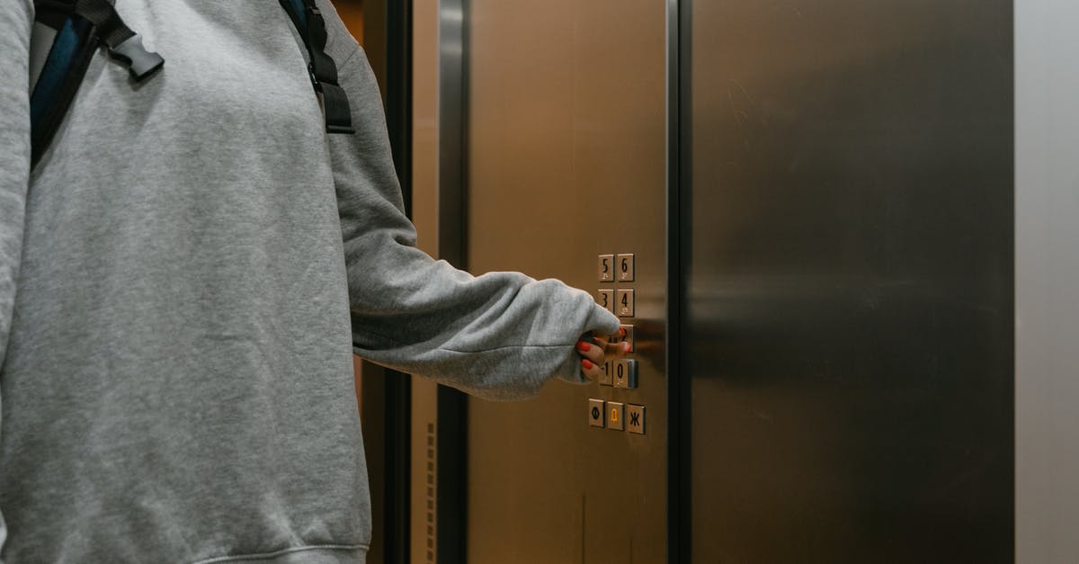 Layover in Warsaw. Will I be quarantined? - Person Pressing the Elevator Button Layover in Warsaw. Will I be quarantined? - Person Pressing the Elevator Button