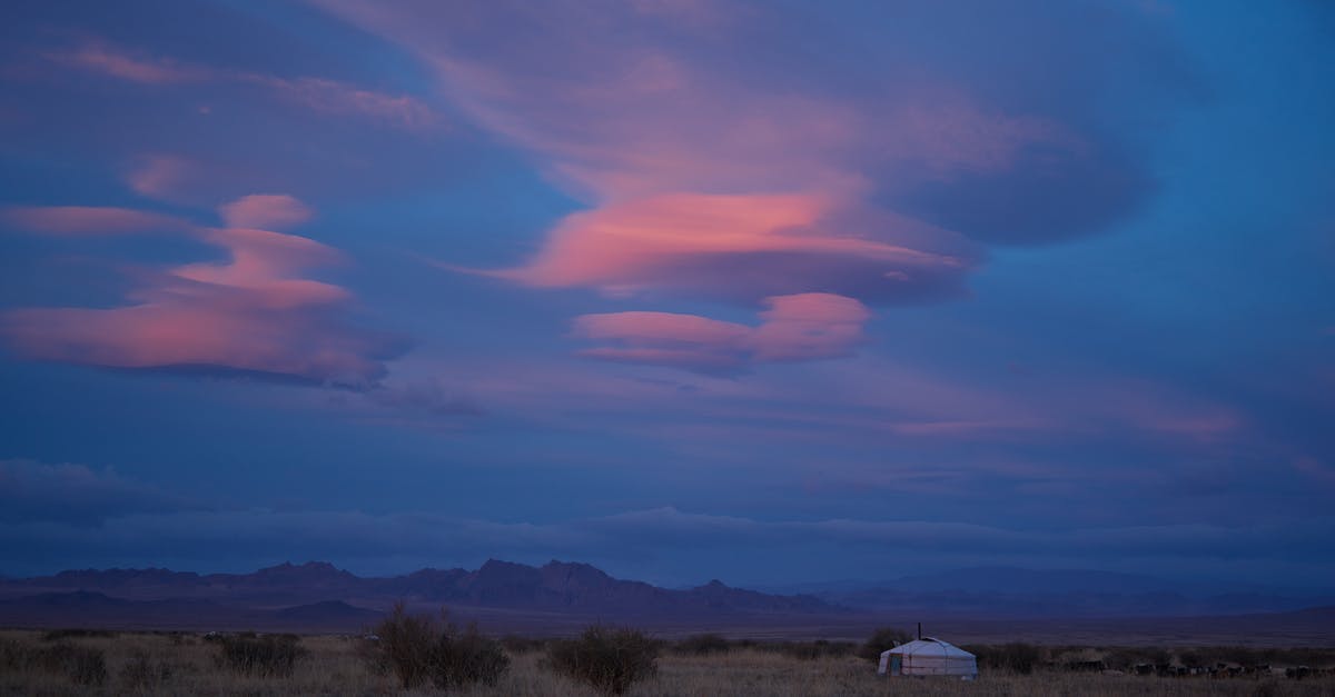 Learning Russian versus Mongolian for visiting Mongolia - Picturesque scenery of pink clouds in dark blue sky under traditional Mongolian ger in prairie with remote mountains during dusk Learning Russian versus Mongolian for visiting Mongolia - Picturesque scenery of pink clouds in dark blue sky under traditional Mongolian ger in prairie with remote mountains during dusk