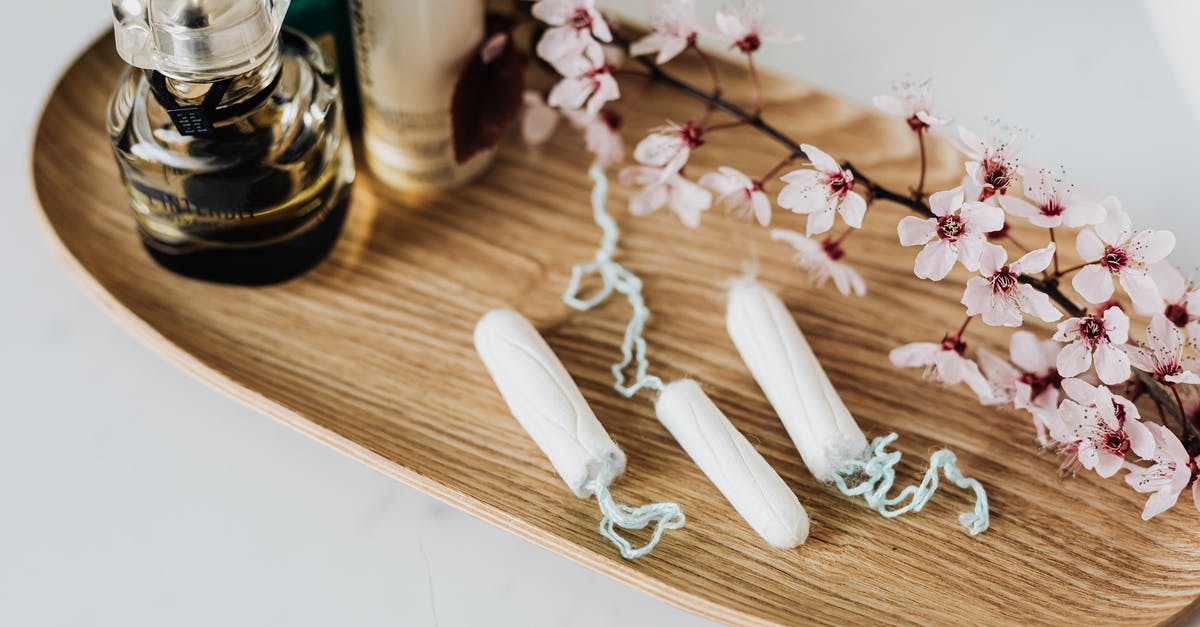 Leaving Singapore the day after visa period ends - Wooden tray with perfume cosmetic products hygienic tampons and flower branch Leaving Singapore the day after visa period ends - Wooden tray with perfume cosmetic products hygienic tampons and flower branch