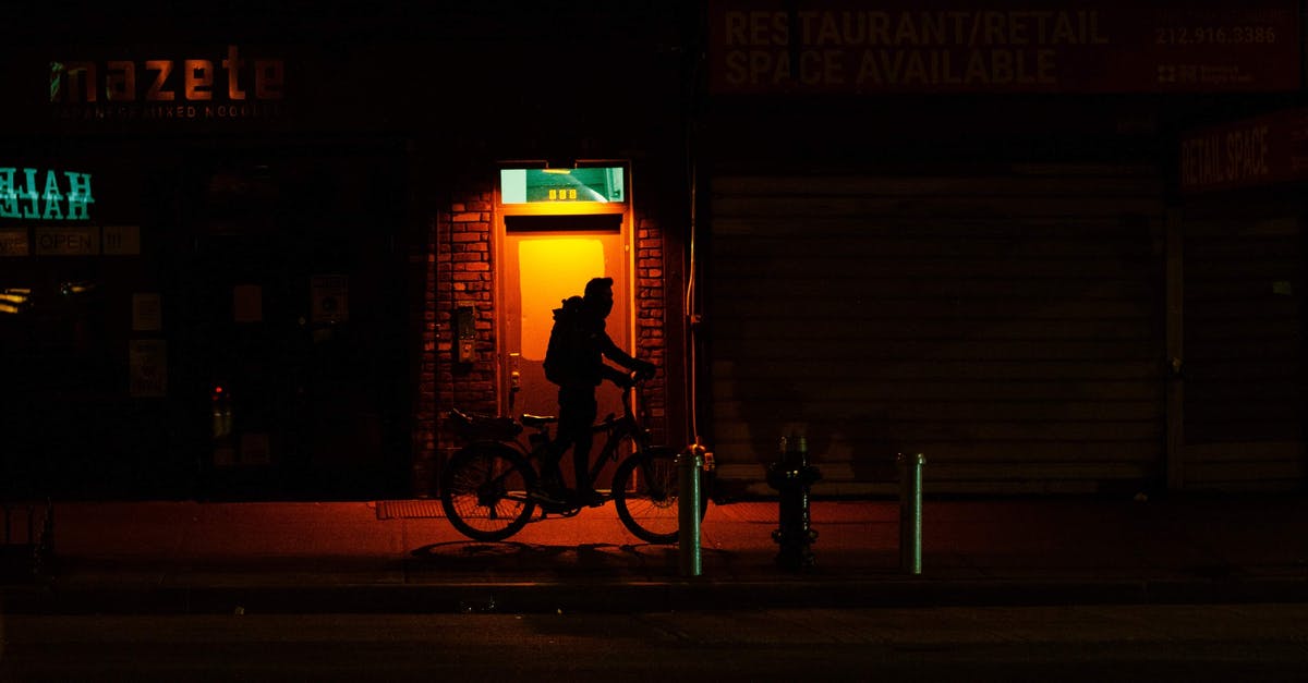 Length of stay in Schengen area - Silhouette of cyclist with bicycle walking on dark sidewalk Length of stay in Schengen area - Silhouette of cyclist with bicycle walking on dark sidewalk