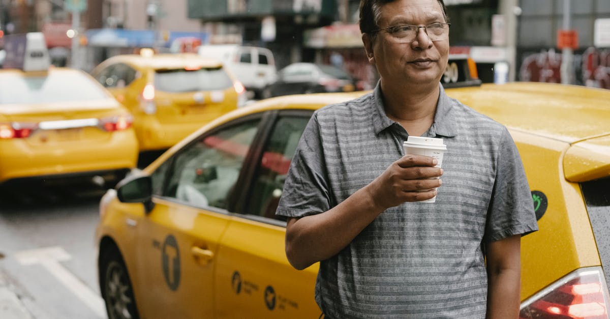 Lisbon Taxi: is it OK to take one Taxi for 2 adults and 3 kids? - Man drinking coffee against taxi on street Lisbon Taxi: is it OK to take one Taxi for 2 adults and 3 kids? - Man drinking coffee against taxi on street