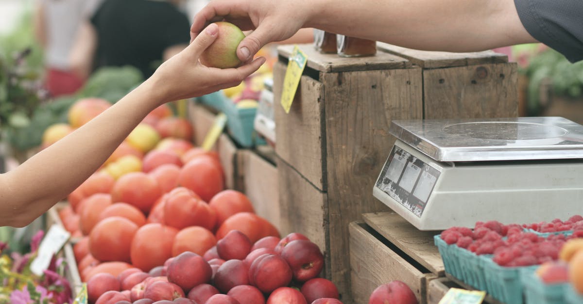 Local markets in Istanbul - Person Giving Fruit to Another Local markets in Istanbul - Person Giving Fruit to Another