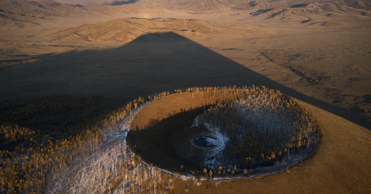 Location in ocean furthest from any land. Are there any established organized travel options for a tourist? - Aerial view of Khorgo extinct volcano grown with forest and covered with snow casting huge dark shadow on valley in national park in Mongolia Location in ocean furthest from any land. Are there any established organized travel options for a tourist? - Aerial view of Khorgo extinct volcano grown with forest and covered with snow casting huge dark shadow on valley in national park in Mongolia