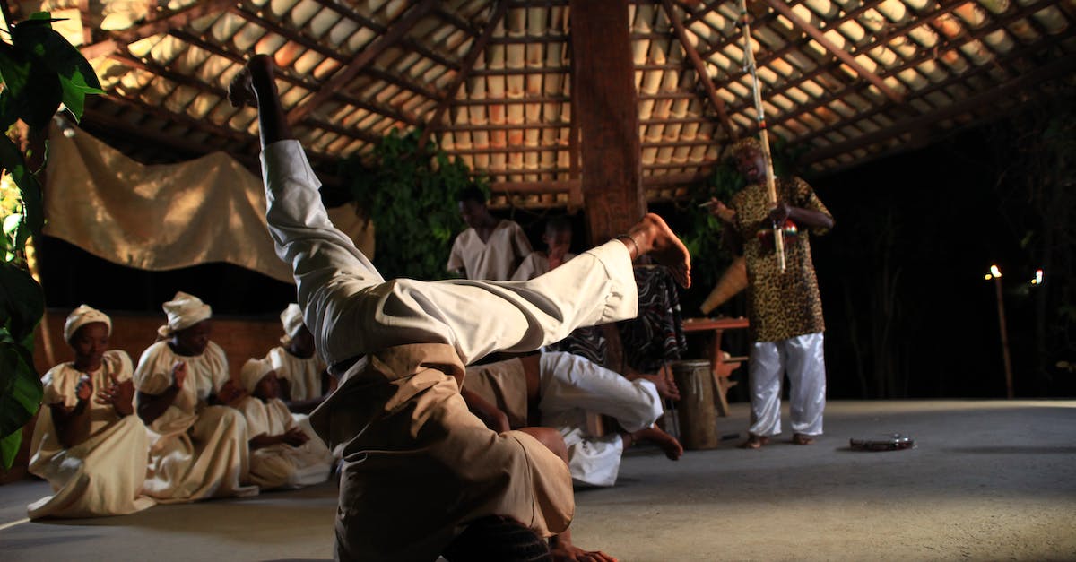 London clubs with nu-folk local bands - Full body of African man dancing on head during traditional ceremony in village