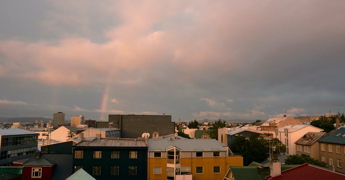 Long Layover (20h) in Reykjavik (Iceland), visit city? - Small town under cloudy sky and rainbow Long Layover (20h) in Reykjavik (Iceland), visit city? - Small town under cloudy sky and rainbow