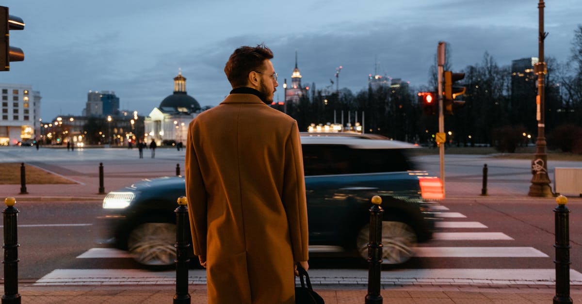 Long term Car rental in Europe - Man Wearing Brown Coat Standing on the Street Long term Car rental in Europe - Man Wearing Brown Coat Standing on the Street