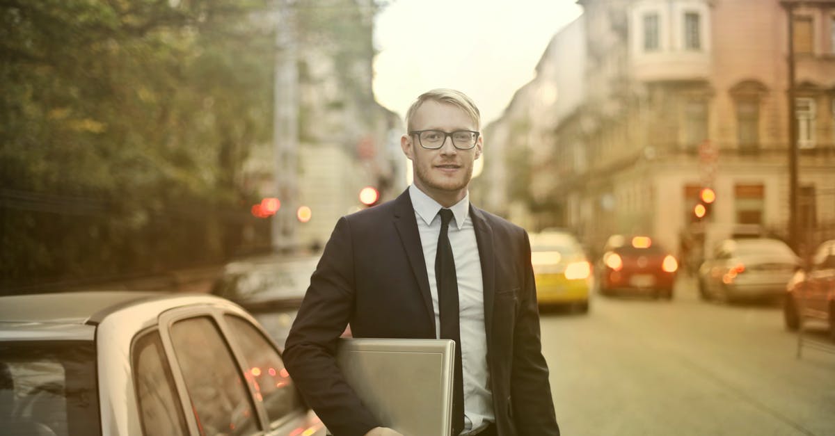 Longest uninhabited road segments - Determined smiling businessman with laptop on street Longest uninhabited road segments - Determined smiling businessman with laptop on street