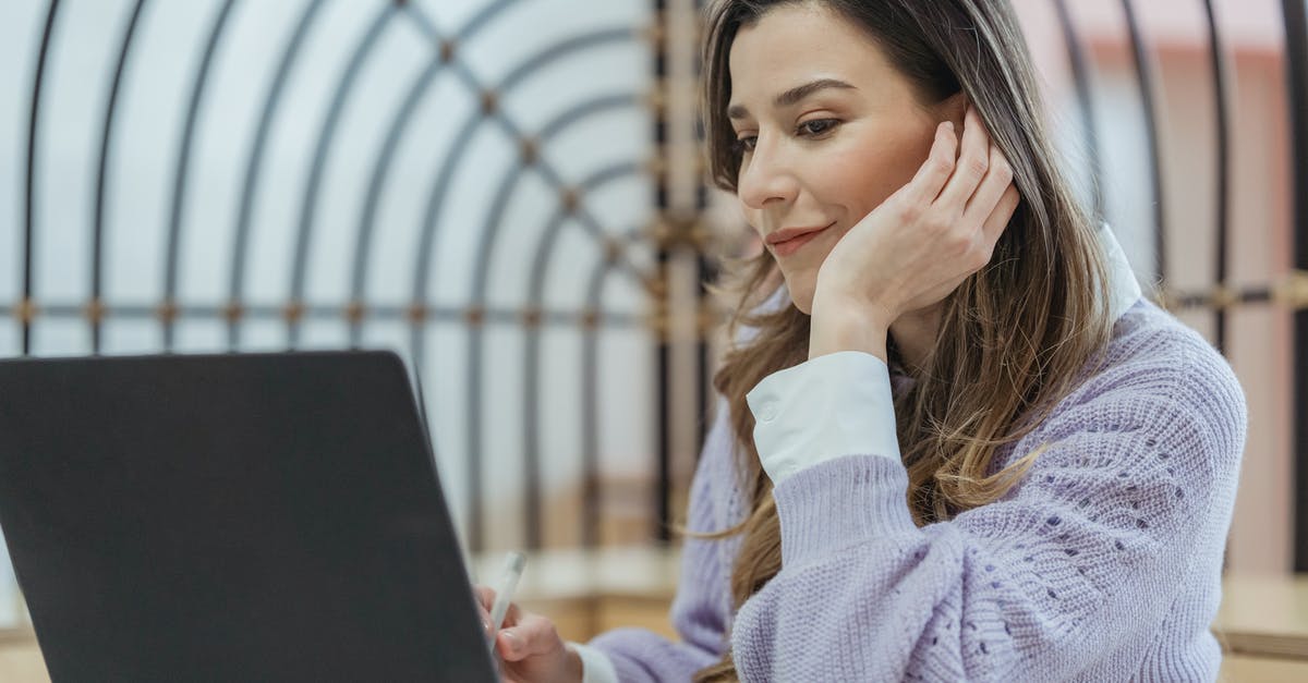 Looking for a good online itinerary organizer / travel planner [closed] - Smiling female teleworker leaning on hand while taking notes in planner during remote work at looking at screen