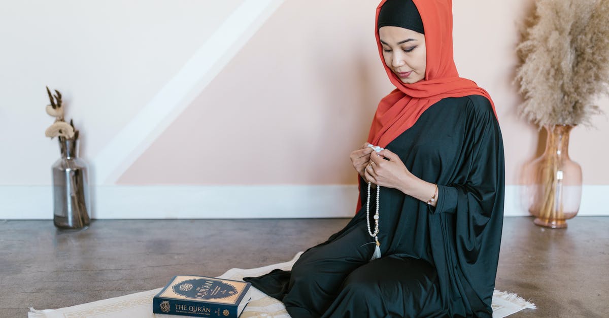 Lots of Muslim headscarfs on a Sunday in Hong Kong - A Woman in Traditional Wear Sitting on a Prayer Rug