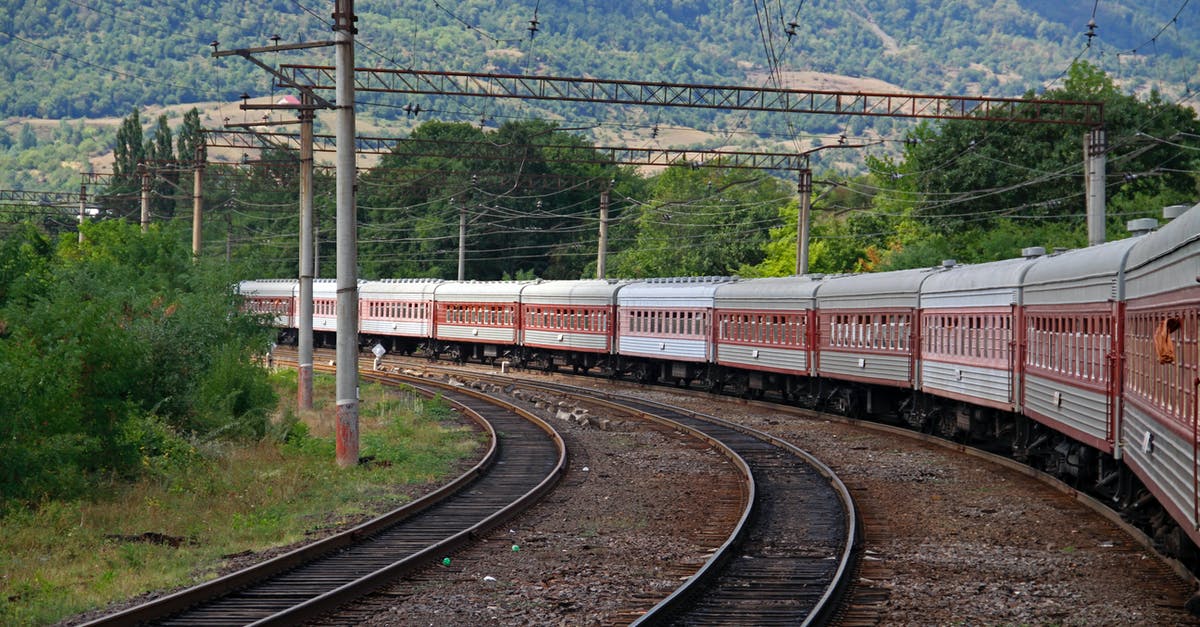 Maeklong Railway Timetable - Red and White Train on Rail Tracks Maeklong Railway Timetable - Red and White Train on Rail Tracks