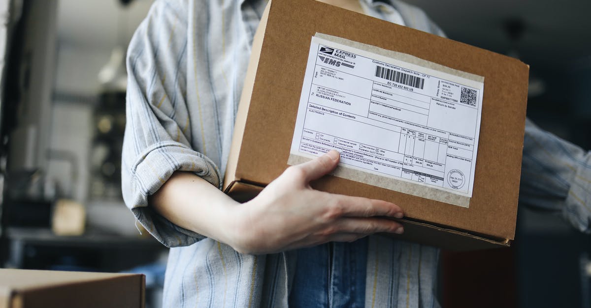 Mailing package at Heathrow during layover - Person Holding Brown Cardboard Box Mailing package at Heathrow during layover - Person Holding Brown Cardboard Box