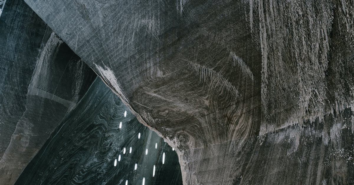 Making calls from Romania - Low angle of abstract textured walls and hanging LED lamps in Salina Turda salt mine in Romania Making calls from Romania - Low angle of abstract textured walls and hanging LED lamps in Salina Turda salt mine in Romania