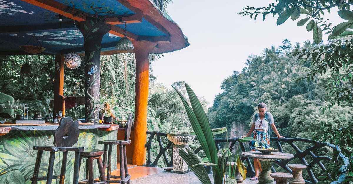 Malaria pills needed for jungle trip in Chiang Mai? - Female tourist standing near wooden fence of bar located among green lush exotic plants during vacation Malaria pills needed for jungle trip in Chiang Mai? - Female tourist standing near wooden fence of bar located among green lush exotic plants during vacation