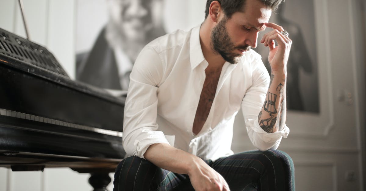 Manchester vs Heathrow: Do they provide similar airport immigration experience to visitors? [closed] - Dramatic tattooed male sitting at piano