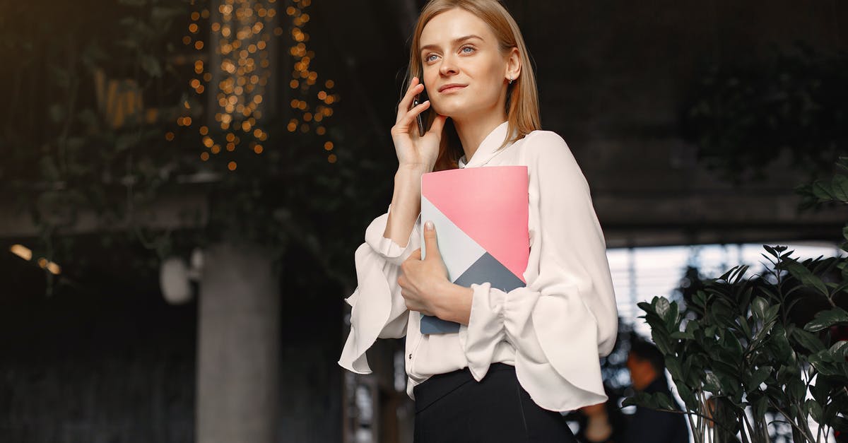 Maximum price for calling inside the EU, from when? - Businesswoman with notebook calling on smartphone in cafe Maximum price for calling inside the EU, from when? - Businesswoman with notebook calling on smartphone in cafe