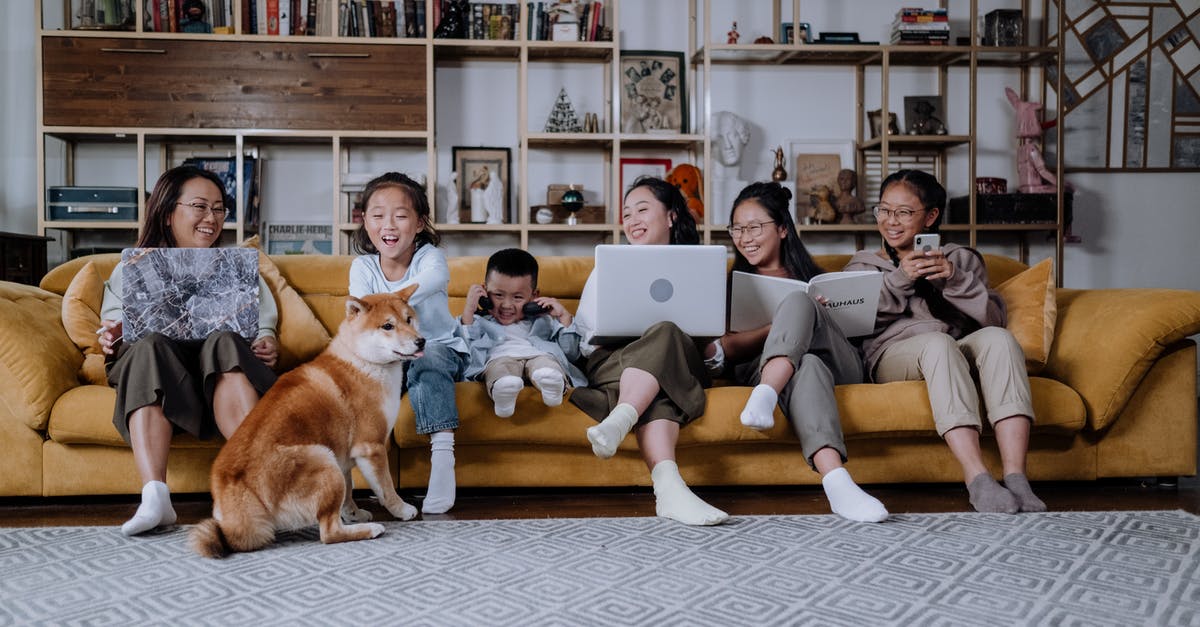 May I bring 3 laptops on a US Domestic flight? - A Happy Family Sitting on the Couch while Playing with their Dog May I bring 3 laptops on a US Domestic flight? - A Happy Family Sitting on the Couch while Playing with their Dog