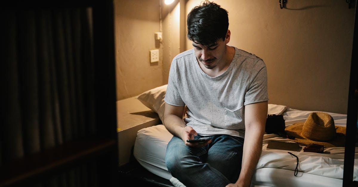 May I wwoof or exchange work for a bed in a hostel in Costa Rica as a tourist? - Man sitting on bed and using smartphone May I wwoof or exchange work for a bed in a hostel in Costa Rica as a tourist? - Man sitting on bed and using smartphone