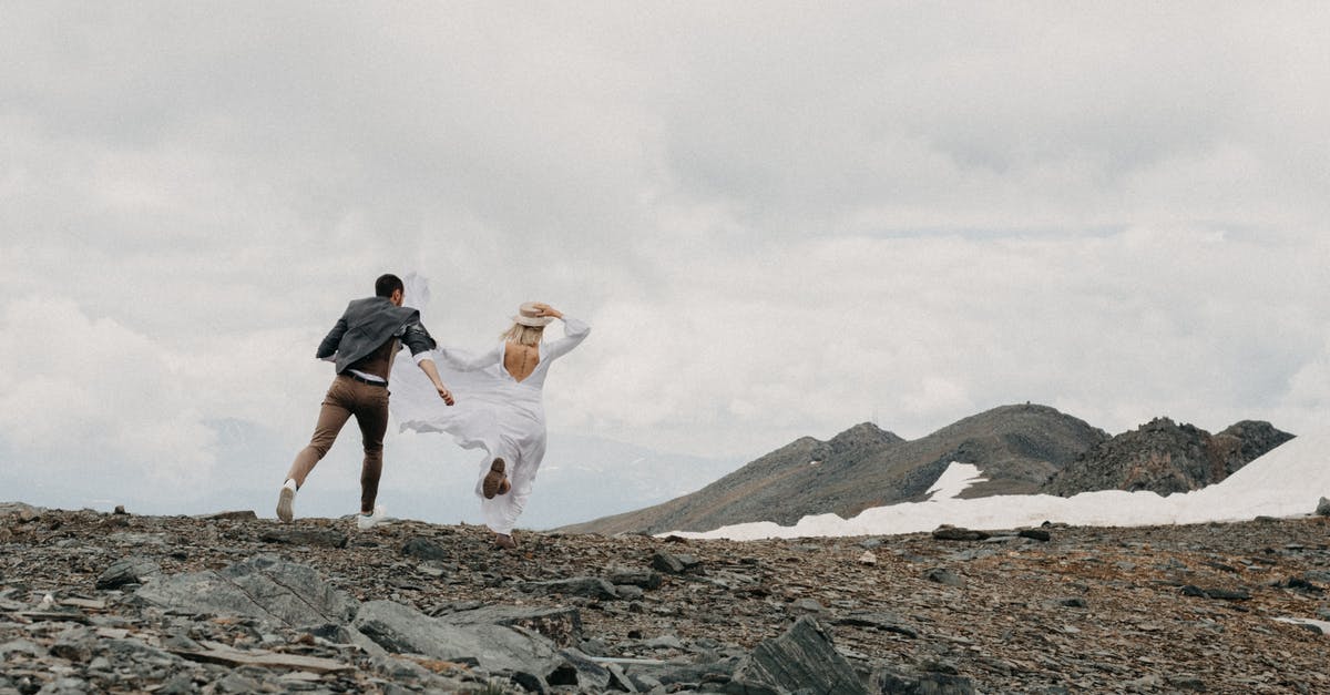 Mexican visa by land versus air - Back view of unrecognizable trendy groom catching up bride in white dress on ridge with snow on wedding day Mexican visa by land versus air - Back view of unrecognizable trendy groom catching up bride in white dress on ridge with snow on wedding day
