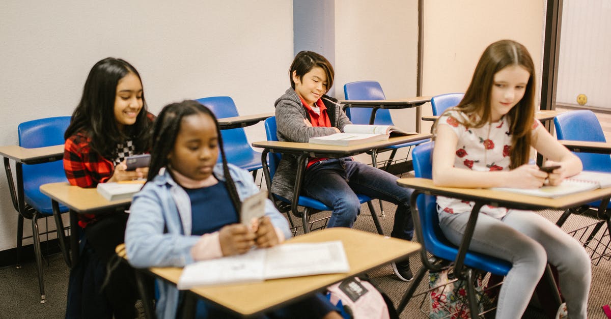 Miles & More: What is a booking class? - Boy Sitting on His Desk While Reading His Book Miles & More: What is a booking class? - Boy Sitting on His Desk While Reading His Book