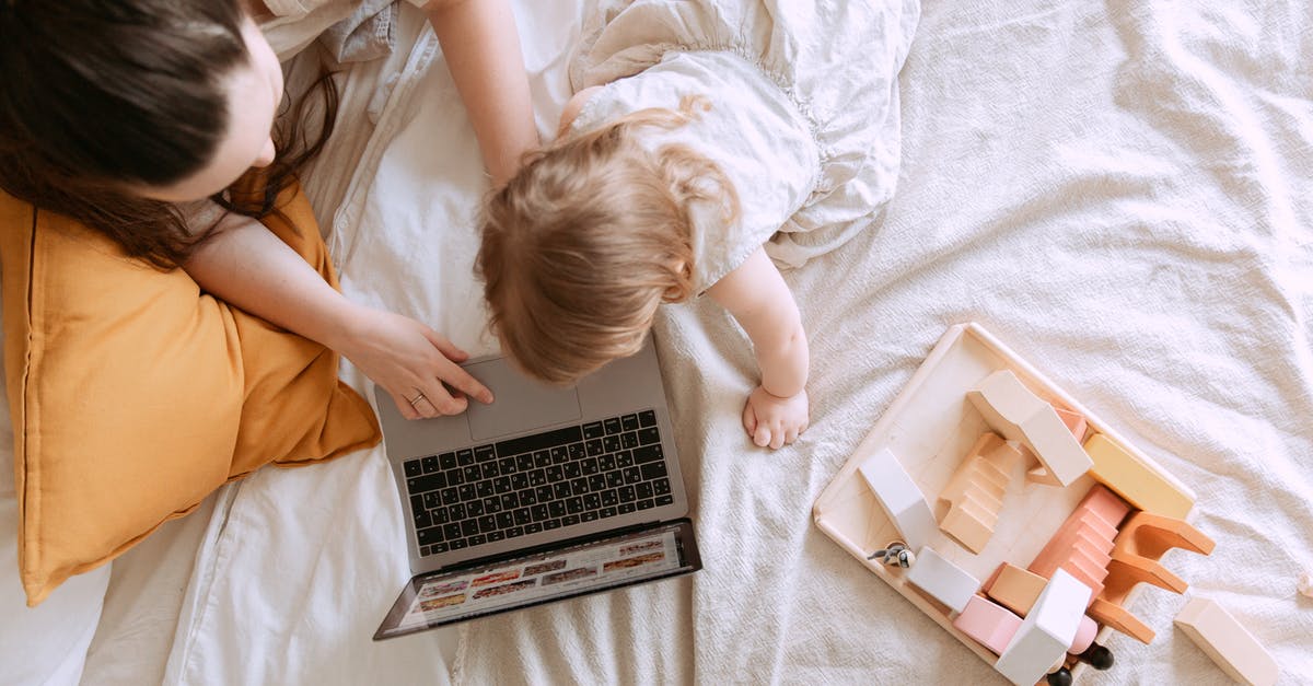 Minor's passport photo has little resemblance. Still good for use or needs to be renewed? - Top view of anonymous mother and little daughter in casual wear searching pictures on netbook while sitting on bed near educational toys in flat