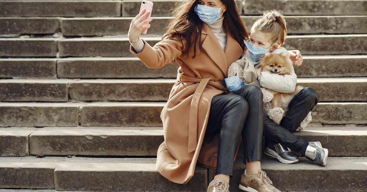 Minor's passport photo has little resemblance. Still good for use or needs to be renewed? - Full body of female and adorable little girl in casual clothes and medical masks sitting on steps with toy in mask and cute dog taking photo on smartphone