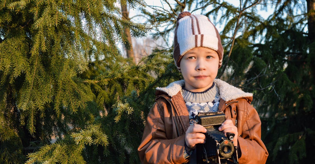 Minor's passport photo has little resemblance. Still good for use or needs to be renewed? - Curious little child with retro camera in forest