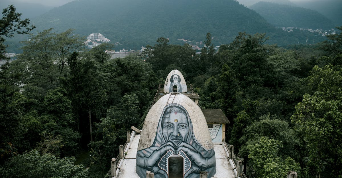 Minors travelling abroad alone from India - From above small domed caves with graffiti on Buddhist meditation house rooftop located in Beatles Ashram in lush green rainforest against cloudy sky in India Minors travelling abroad alone from India - From above small domed caves with graffiti on Buddhist meditation house rooftop located in Beatles Ashram in lush green rainforest against cloudy sky in India