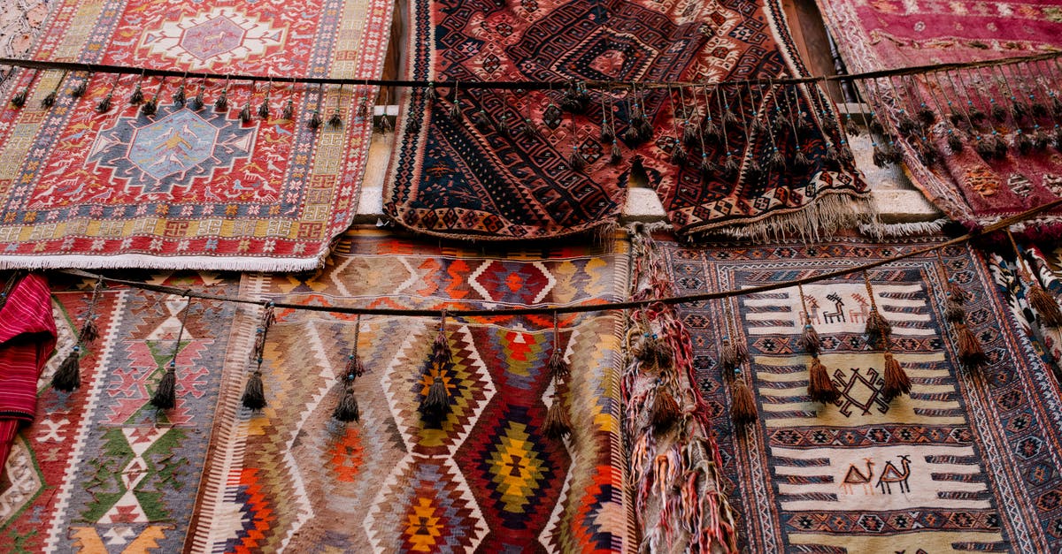 Missing middle name in travel documents - Colorful handmade weaved with oriental ornament middle east rugs hanging in open market Missing middle name in travel documents - Colorful handmade weaved with oriental ornament middle east rugs hanging in open market