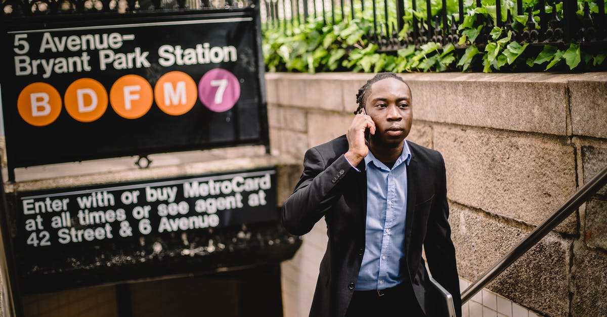 Mobile connectivity in Budapest subway - Well dressed African American businessman talking on cellphone while exiting New York subway on summer day Mobile connectivity in Budapest subway - Well dressed African American businessman talking on cellphone while exiting New York subway on summer day