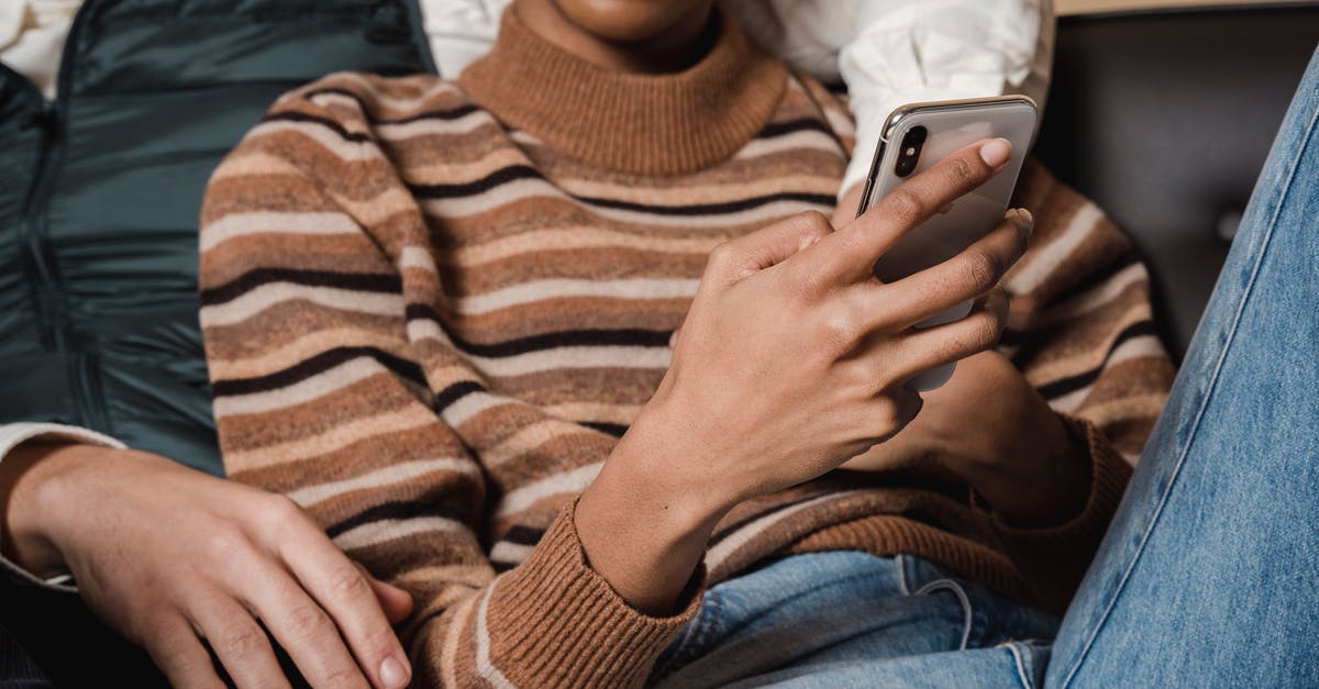 Mobile internet (3G) in UK for some days - Black woman using smartphone while lying on sofa with boyfriend Mobile internet (3G) in UK for some days - Black woman using smartphone while lying on sofa with boyfriend