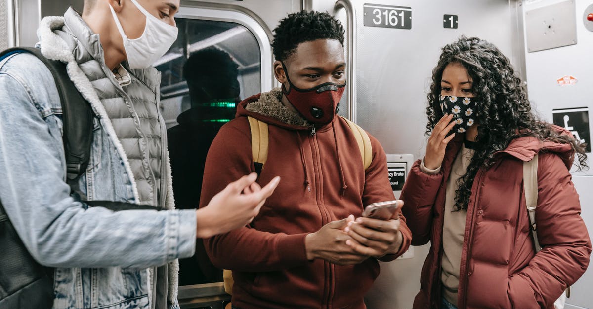 Moscow subway last train time - Faceless multiethnic students in masks in subway train with phone Moscow subway last train time - Faceless multiethnic students in masks in subway train with phone