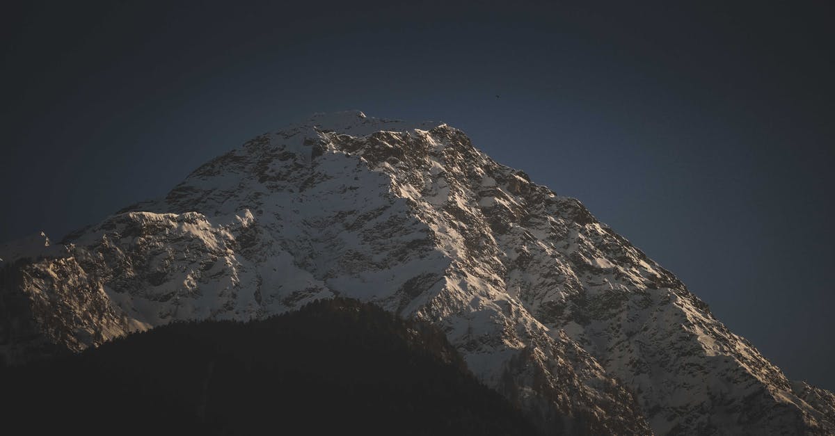 Mount Everest climb cost and total time - Snowy mountain peaks under dark blue sky Mount Everest climb cost and total time - Snowy mountain peaks under dark blue sky