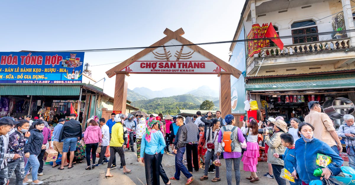 Mount Everest without the crowd - Anonymous ethnic people strolling on walkway against buildings and misty mountains in local bazaar in town Mount Everest without the crowd - Anonymous ethnic people strolling on walkway against buildings and misty mountains in local bazaar in town