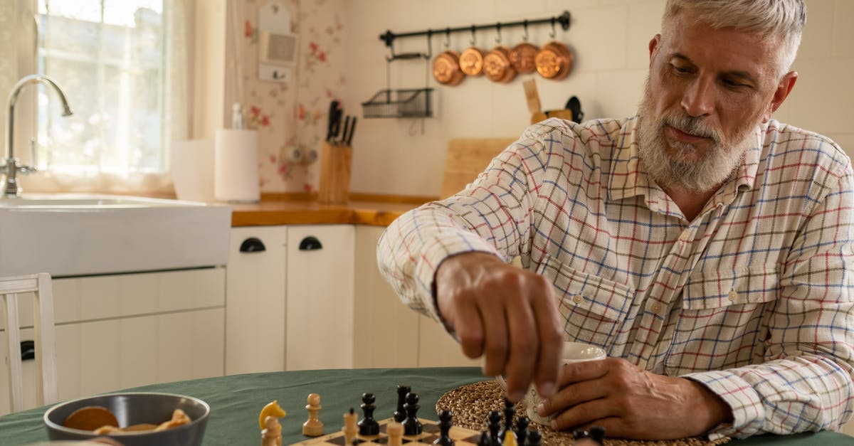 Moving between Schengen Countries - Elderly Man Moving Chess Piece Across Board Moving between Schengen Countries - Elderly Man Moving Chess Piece Across Board