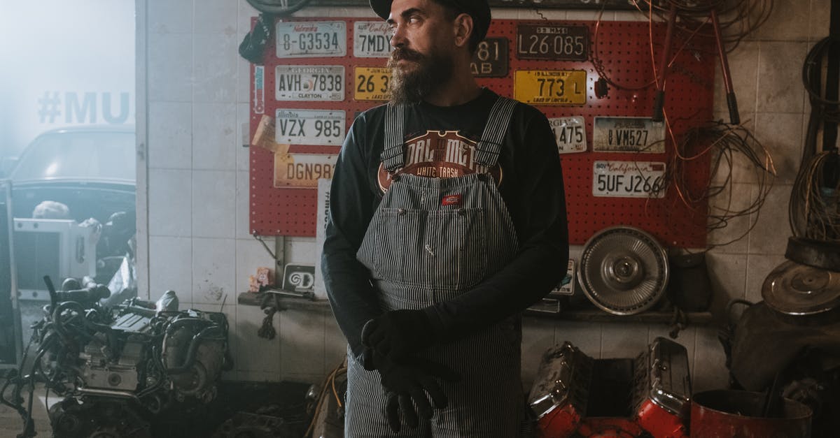 Multiple layers of license plates on egypt cars - Man in Black and White Crew Neck T-shirt Standing Near Red and Black Wall Multiple layers of license plates on egypt cars - Man in Black and White Crew Neck T-shirt Standing Near Red and Black Wall