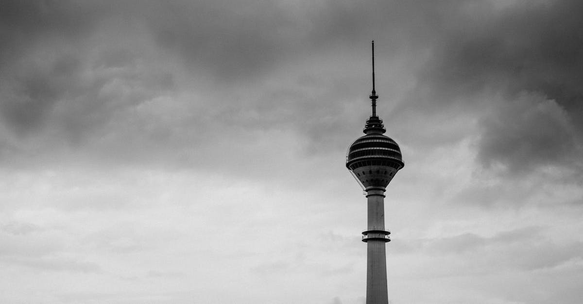 Muscat to Penang via Kuala Lumpur - Grayscale Photo of Tower Under Cloudy Sky Muscat to Penang via Kuala Lumpur - Grayscale Photo of Tower Under Cloudy Sky