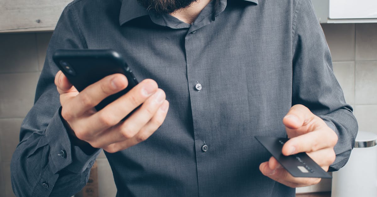 My credit card has no magnetic stripe. Is this a problem in the USA? - Man in Blue Dress Shirt Holding Black Smartphone My credit card has no magnetic stripe. Is this a problem in the USA? - Man in Blue Dress Shirt Holding Black Smartphone