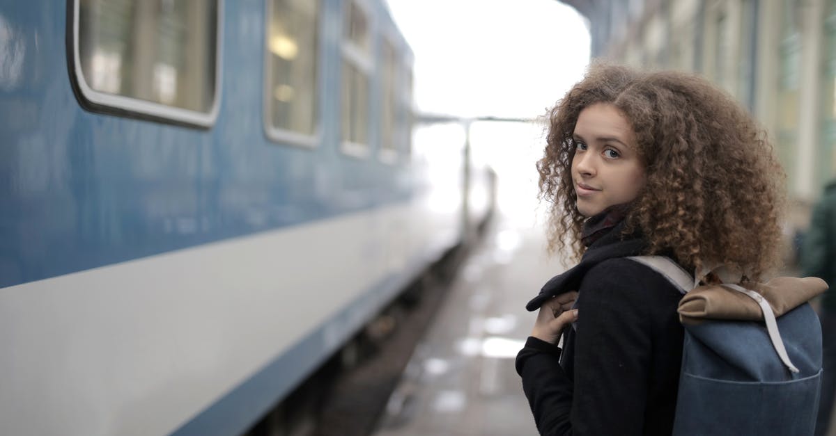 My German student visa expired last month. Can i travel back to India? - Charming young lady with backpack standing on platform near train