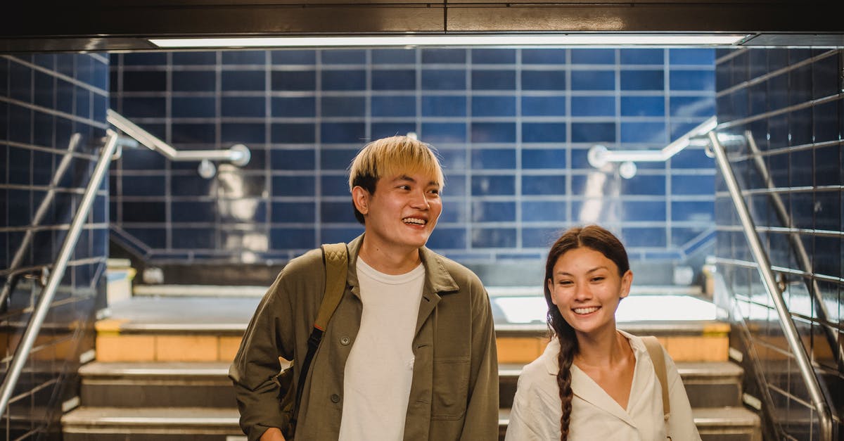 my girlfriend is colombia and needs to pass through UK - Happy Asian couple walking downstairs in underground walkway my girlfriend is colombia and needs to pass through UK - Happy Asian couple walking downstairs in underground walkway