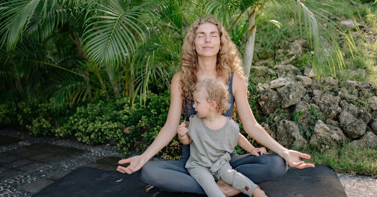 My son is traveling to Italy with his school will he need a green card and if so why [closed] - Full body happy relaxed mother sitting with eyes closed in lotus pose with cute boy on laps while practicing yoga in tropical green park