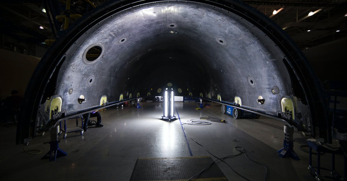 Nantes airport shuttle details - Illuminated tunnel with rocket construction equipment and lights in dark contemporary spacious industrial factory Nantes airport shuttle details - Illuminated tunnel with rocket construction equipment and lights in dark contemporary spacious industrial factory
