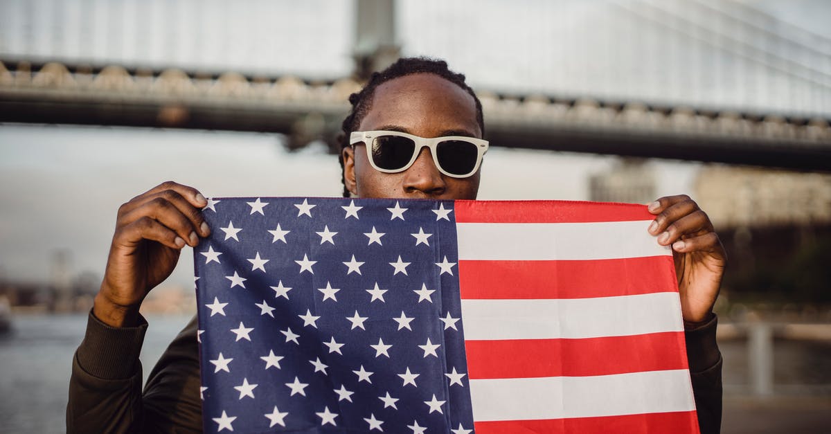 National flight with expired tourist visa - Young African American male with American Flag bandana against bridge National flight with expired tourist visa - Young African American male with American Flag bandana against bridge
