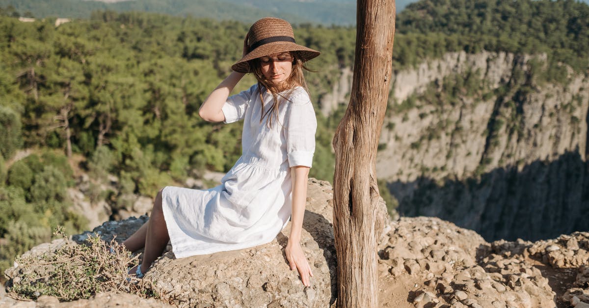Nauseous Anxiety Travel - A Woman in White Dress Sitting on the Edge of a Mountain Nauseous Anxiety Travel - A Woman in White Dress Sitting on the Edge of a Mountain